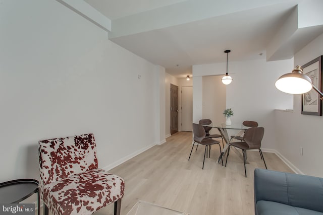 dining area featuring light wood-style flooring and baseboards