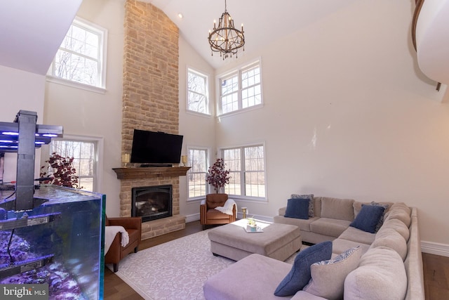 living area featuring a wealth of natural light, baseboards, an inviting chandelier, and wood finished floors