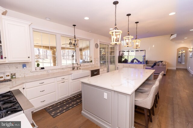 kitchen with a kitchen island, an inviting chandelier, and white cabinets