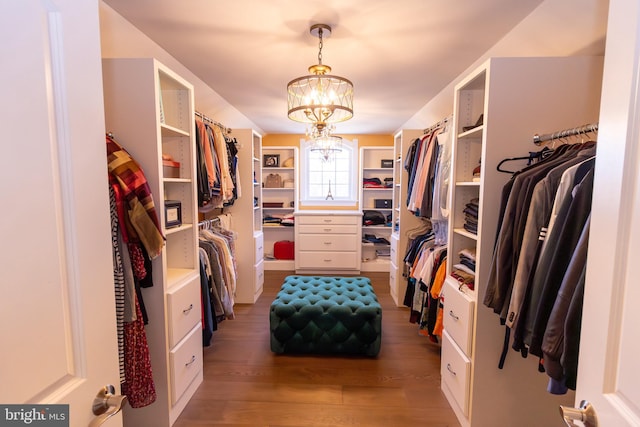 spacious closet with a chandelier and wood finished floors