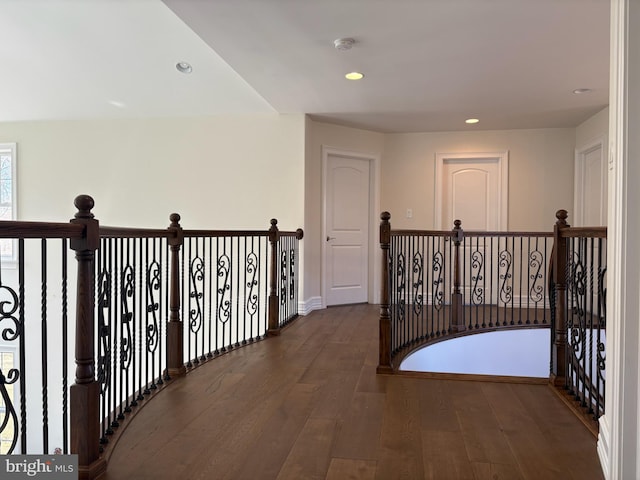 corridor with wood finished floors, recessed lighting, and an upstairs landing