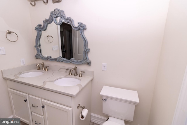 bathroom featuring a sink, toilet, and double vanity