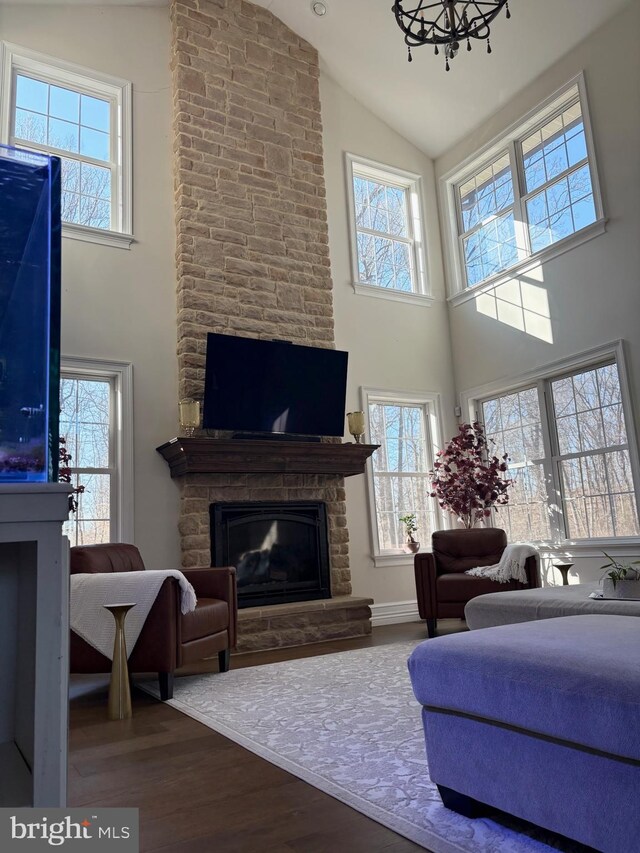 living room with a fireplace, wood finished floors, baseboards, and high vaulted ceiling