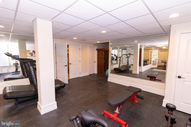 exercise room featuring recessed lighting, a paneled ceiling, and baseboards