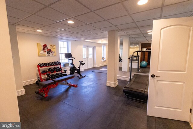exercise room with recessed lighting, a paneled ceiling, and baseboards
