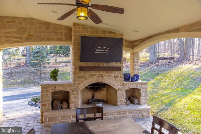 view of patio / terrace with an outdoor stone fireplace and ceiling fan
