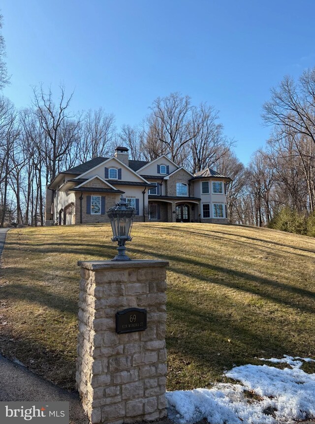 view of front of home with a chimney and a front lawn