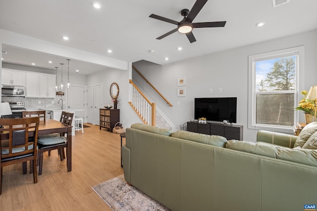 living room featuring recessed lighting, visible vents, a ceiling fan, stairway, and light wood-type flooring