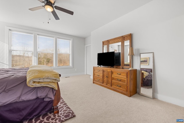 carpeted bedroom with ceiling fan and baseboards