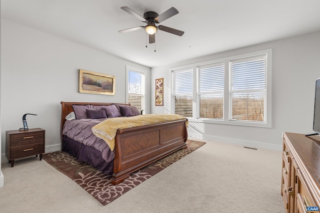 carpeted bedroom featuring baseboards, visible vents, and a ceiling fan