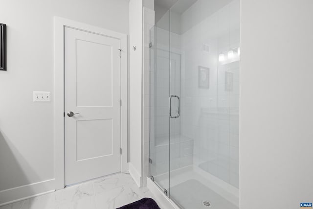 full bathroom with marble finish floor and a shower stall