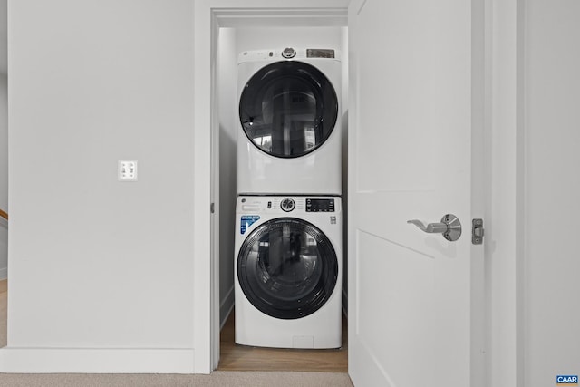 washroom with stacked washer and dryer and laundry area