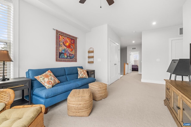 living area with recessed lighting, light colored carpet, visible vents, and baseboards