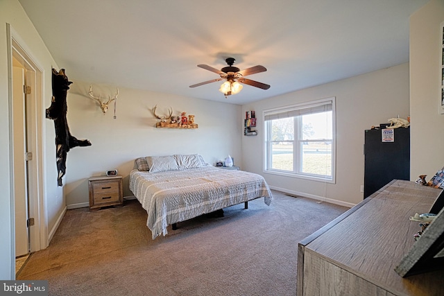 carpeted bedroom with ceiling fan and baseboards