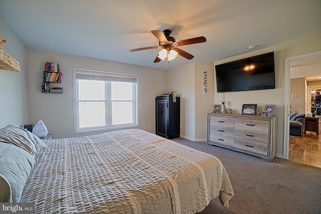 carpeted bedroom with a ceiling fan and baseboards