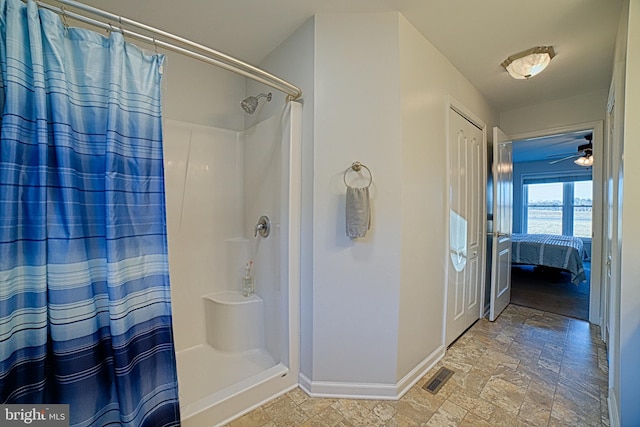 full bathroom with stone finish flooring, curtained shower, visible vents, and baseboards