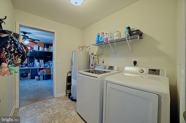 laundry room with laundry area, separate washer and dryer, baseboards, water heater, and stone finish floor