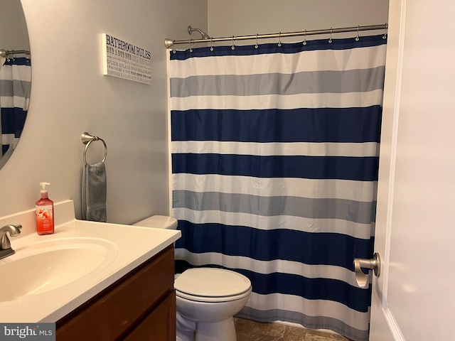 bathroom with toilet, stone finish floor, a shower with shower curtain, and vanity