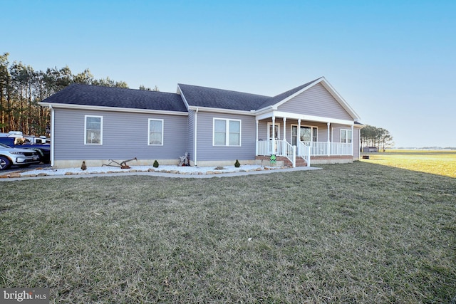 ranch-style home with covered porch, roof with shingles, and a front lawn