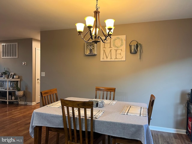 dining room with a chandelier, dark wood-type flooring, visible vents, and baseboards