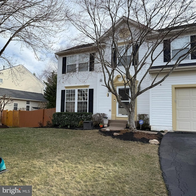 view of front of property with a garage, entry steps, a front lawn, and fence