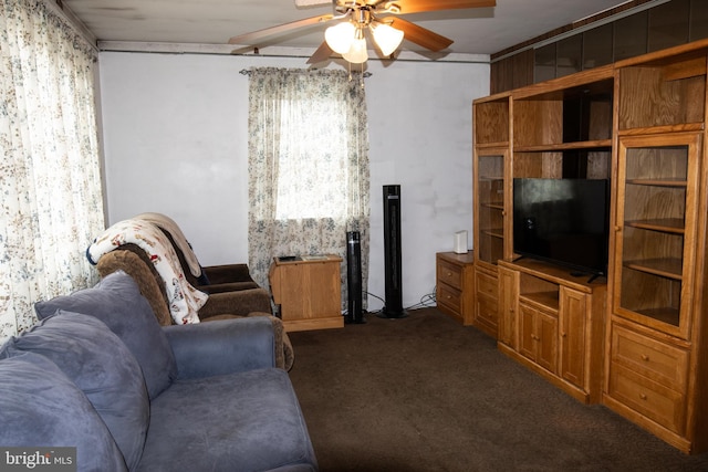 living area with a ceiling fan and dark carpet