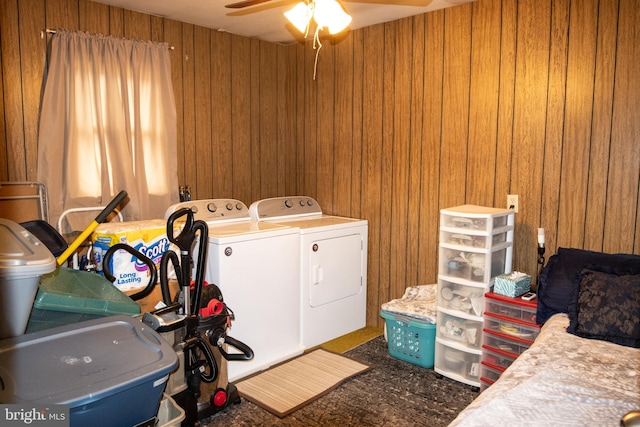 clothes washing area with washer and dryer, laundry area, wood walls, and ceiling fan