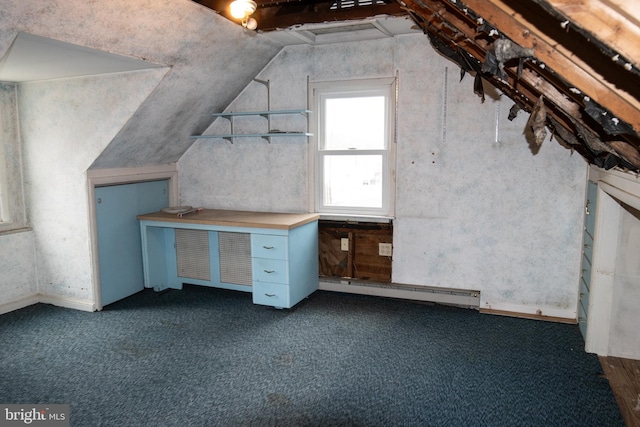 unfurnished office with a baseboard heating unit, vaulted ceiling, and dark carpet