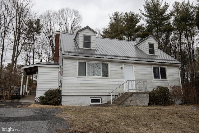 cape cod house with metal roof and a chimney