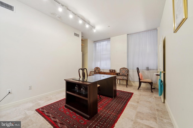 office space featuring track lighting, visible vents, and baseboards