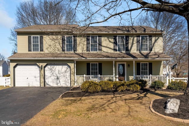 view of front of home with a garage, driveway, and a porch