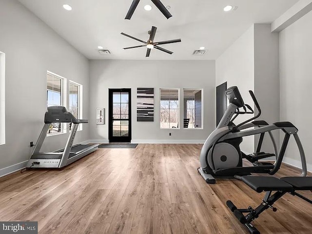 exercise area with baseboards, visible vents, wood finished floors, and a ceiling fan