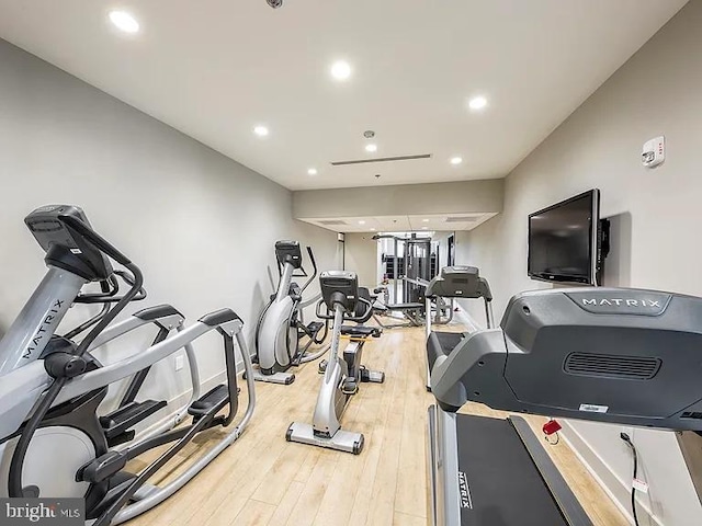 exercise room featuring wood finished floors and recessed lighting