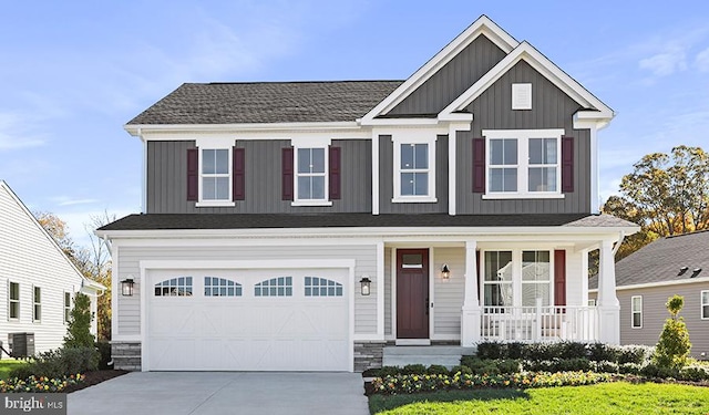 view of front facade featuring a porch, board and batten siding, cooling unit, stone siding, and driveway