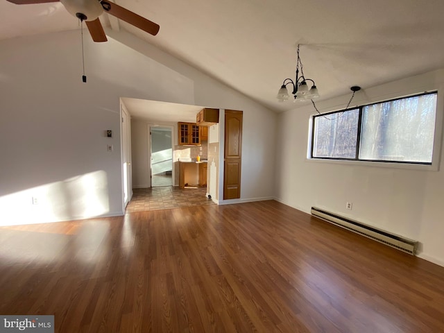 unfurnished living room with vaulted ceiling, baseboard heating, wood finished floors, and ceiling fan with notable chandelier