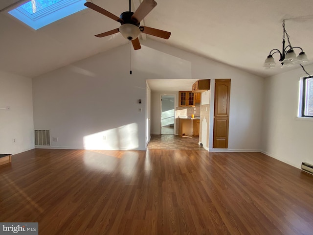 unfurnished living room with a skylight, visible vents, wood finished floors, high vaulted ceiling, and ceiling fan with notable chandelier