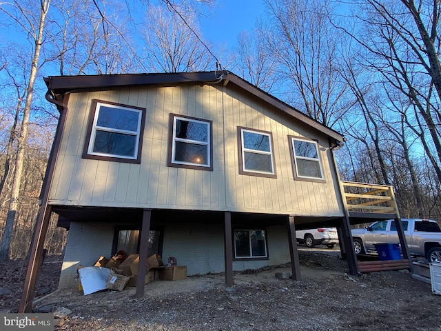 view of front of home with a deck, a carport, and brick siding