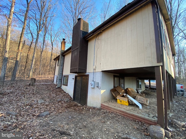 view of property exterior featuring brick siding and a chimney