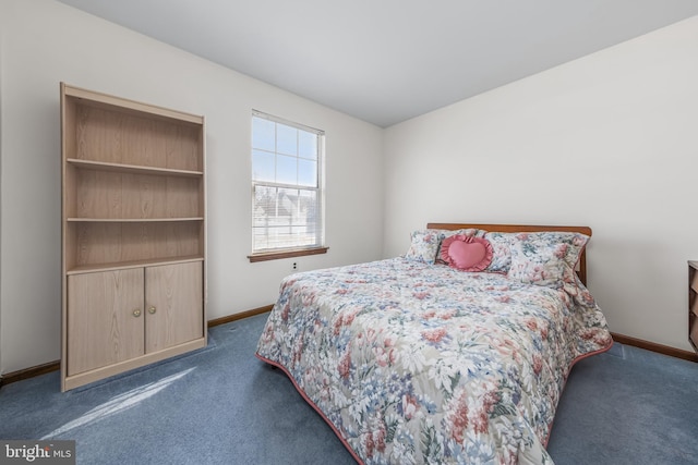 bedroom with dark carpet and baseboards