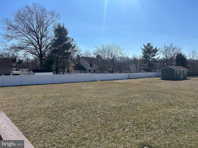 view of yard with a shed, fence, and an outdoor structure