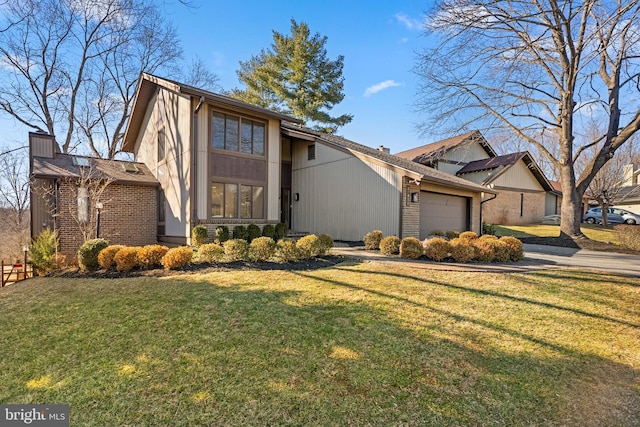 mid-century modern home featuring a front yard, brick siding, a chimney, and an attached garage