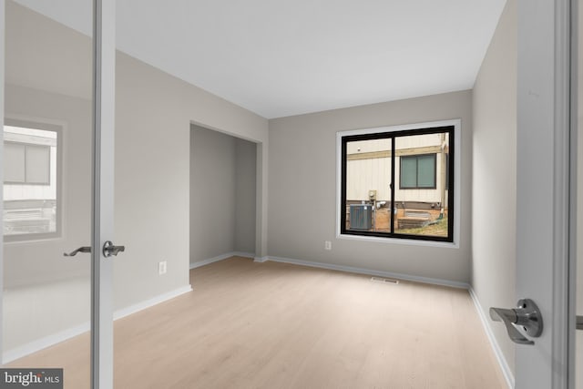 unfurnished bedroom with visible vents, baseboards, and wood finished floors