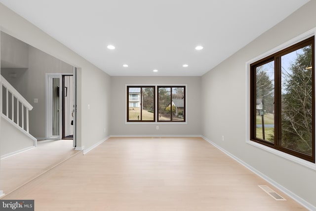 empty room featuring stairway, baseboards, visible vents, and recessed lighting