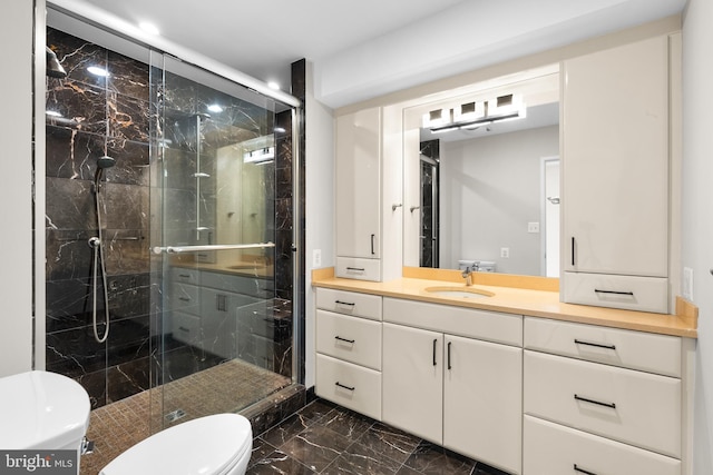 full bath featuring a marble finish shower, marble finish floor, vanity, and toilet