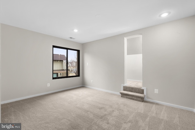 carpeted empty room with visible vents, stairs, baseboards, and recessed lighting