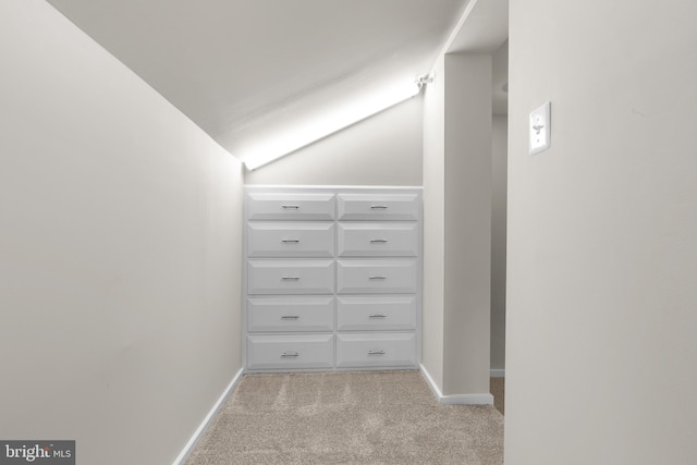 spacious closet featuring light carpet and vaulted ceiling