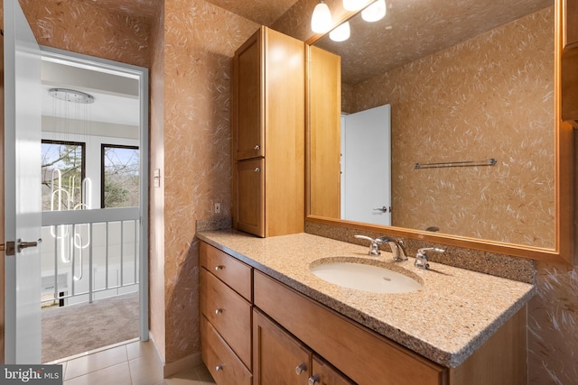 bathroom featuring a textured ceiling, tile patterned flooring, vanity, and wallpapered walls