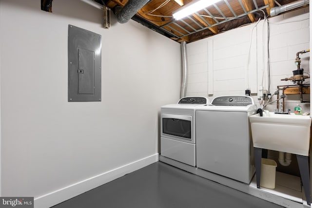 laundry area with laundry area, separate washer and dryer, baseboards, electric panel, and concrete block wall