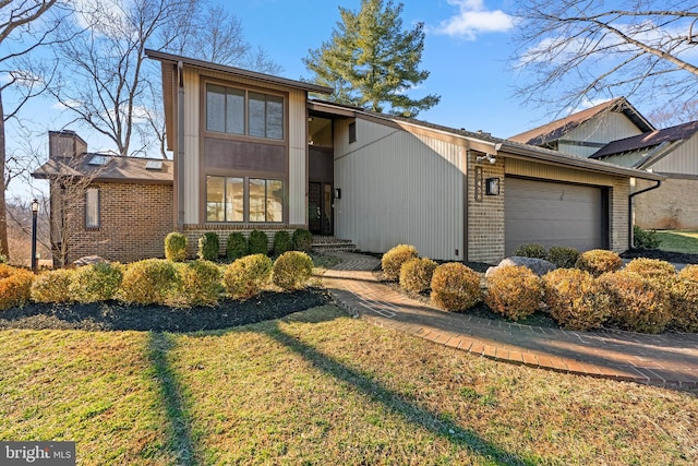 mid-century home featuring an attached garage, a front lawn, and brick siding