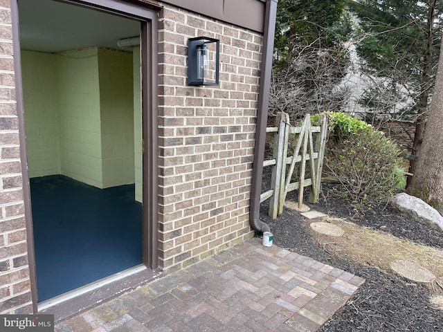 property entrance with brick siding and fence